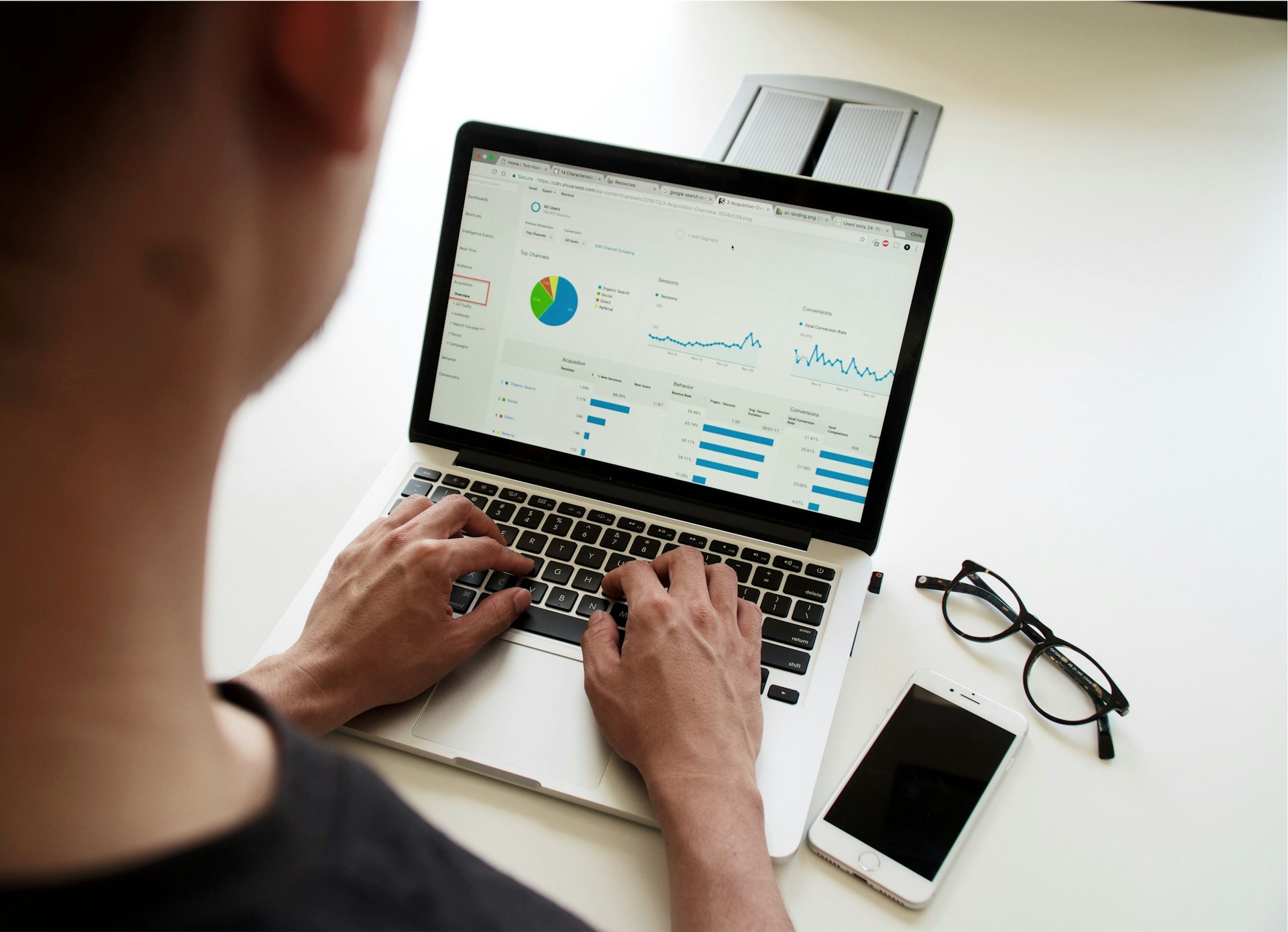 person-looking-at-survey-data-on-a-laptop-photographed-from-behind